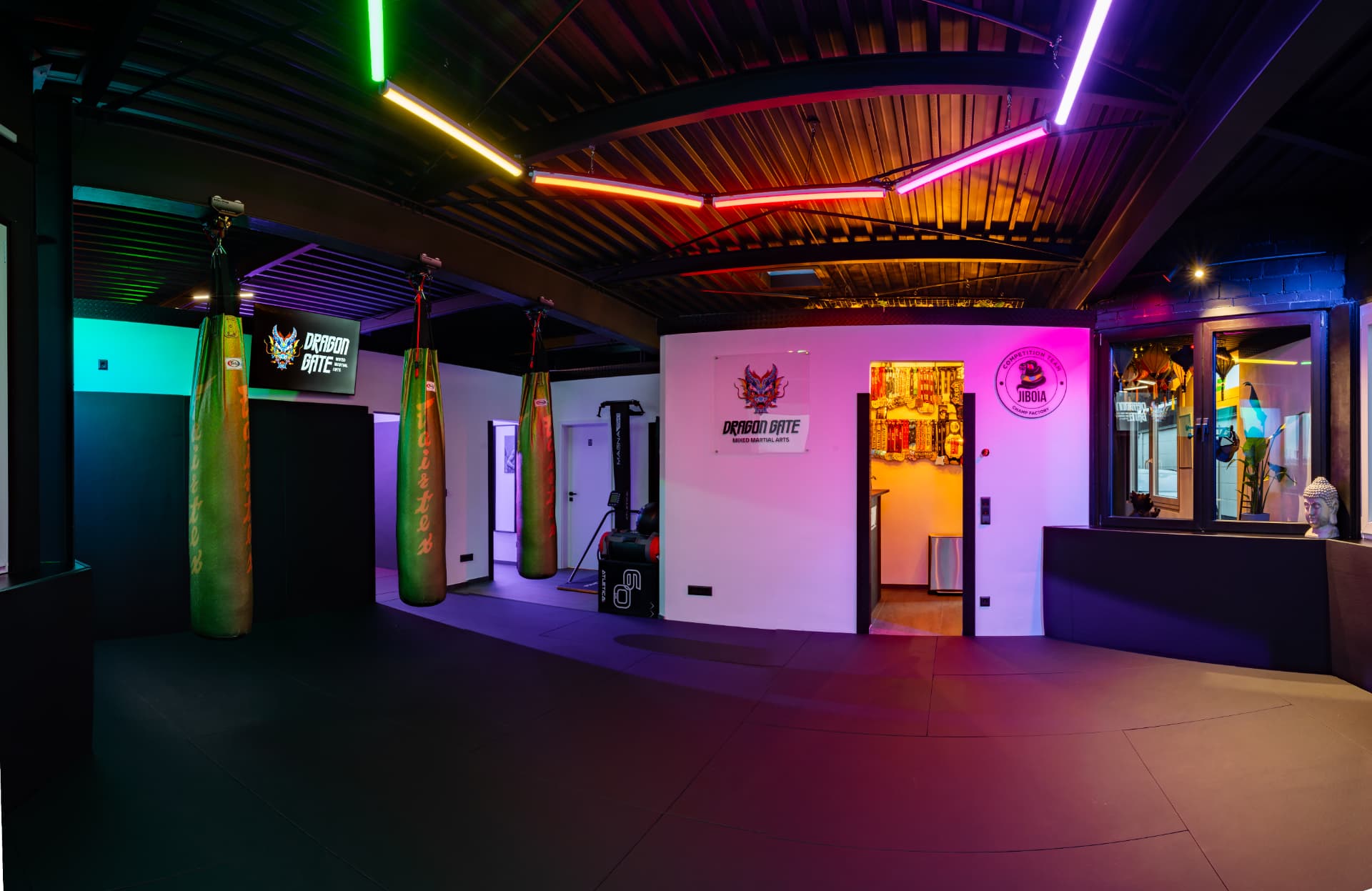 DGMMA Haupttrainingsraum mit Boxsäcken und Neon-Beleuchtung